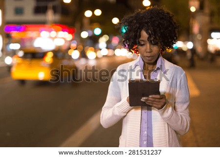 Young African American black woman using tablet pc at night in New York City
