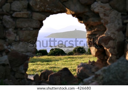tower on remote island seen through a hole in a stone wall