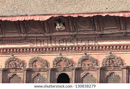 The images of Shiva and his consort Parvati peep out from the upstairs window. Shiva Parvati red brick hindu temple of the  XVIII century-Durbar Square-Kathmandu-Nepal.
