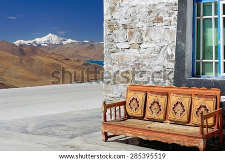 Armchair overlooking the 638 km2-130 km.E'W-70 km.N'S-250 long bank-4441 ms.alt.-turquoise colored Yamdrok Tso-Upper Pasture lake and mt.Nojin Kangsang at 7206 ms.Kamba La-Lhoka or Shannan pref.-Tibet Stok fotoğraf © 