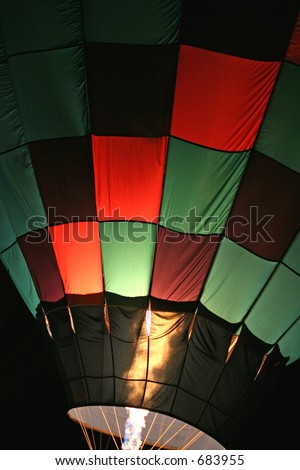 Red And Green Checkered Hot Air Balloon With Burners on at Night