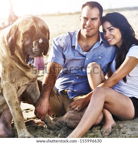 couple with pet dog on the beach