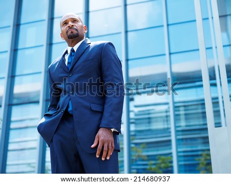 confident african businessman in front of glass building