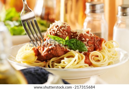 eating spaghetti and meatballs with fork
