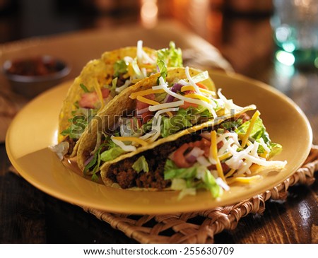 plate of tacos with yellow hard shells and beef