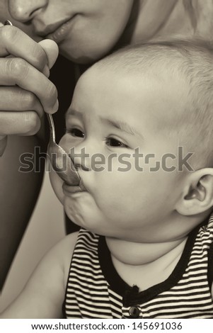 The small child, eats from a spoon