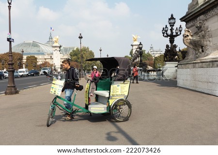 PARIS, FRANCE - September 24, 2014:  bicycle  taxi waits for tourists around the city.