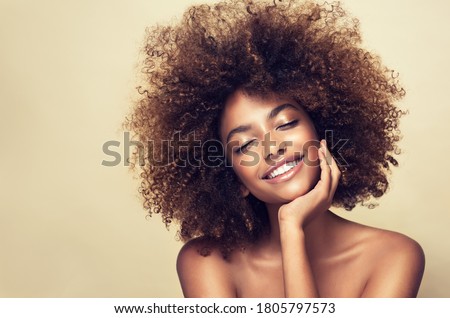 Beauty portrait of african american woman with clean healthy skin on beige background. Smiling beautiful afro girl.Curly black hair Stock fotó © 