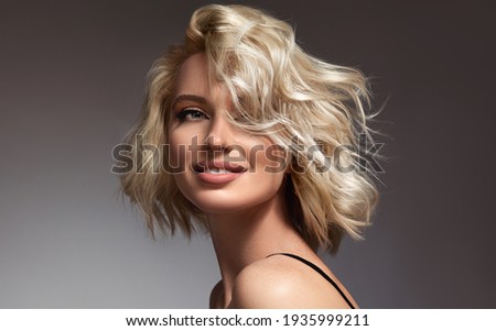 Beautiful model girl with short hair .Beauty  smiling woman with blonde curly hairstyle dye .Fashion, cosmetics and makeup Foto stock © 