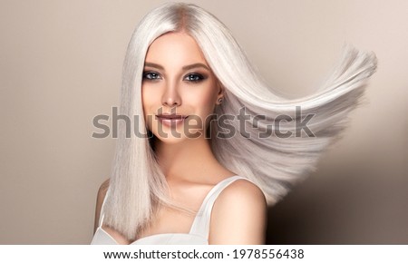 Beautiful girl with hair coloring in ultra blond. Stylish hairstyle done in a beauty salon. Fashion, cosmetics and makeup