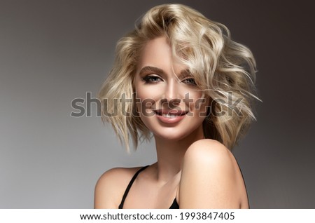 Beautiful model girl with short hair .Beauty woman with blonde curly hairstyle dye .Fashion, cosmetics and makeup Foto d'archivio © 