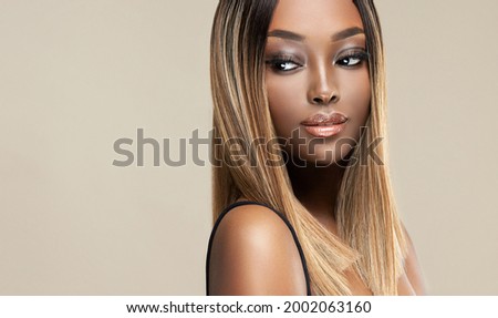 Beautiful African American woman with dyed and straight hair. The beauty of an afro black girl with a bob smooth hairstyle and toning. Keratin straightening. Treatment, care and spa procedures.