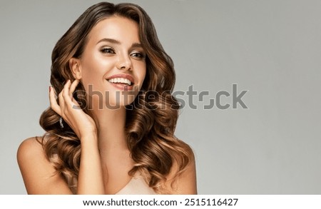 Beautiful white-toothed smiling woman   with long  and   shiny wavy  hair .  Beauty happy model girl with curly hairstyle . Gorgeous white teeth in a smile