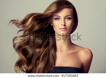 Brunette  girl with long  and   shiny wavy hair .  Beautiful  model with curly hairstyle . Foto stock © 