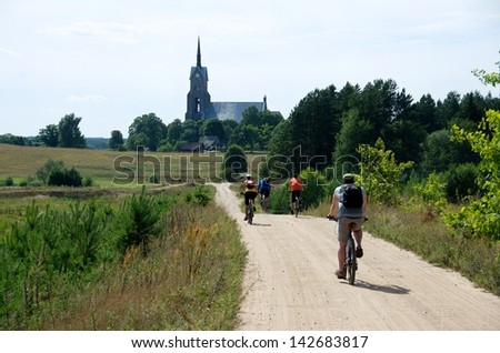 Group of tourist riding bicycles by dirty road in countryside,group cyclists on a way between fields,cyclists touring in Lithuania, by bicycle in Lithuania countryside, cycling bicycle on dirty road