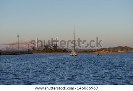 Olbia,Sardinia,Yacht and small boat sailing towards sunset in dark background with the mountains,sunset background, yacht in the sunset,water sport, yacht sailing in sunset,Italy, holiday in the sea