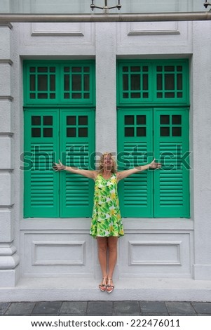 Happy woman on summer day with green doors background, happy woman, Singapore, Asia, woman enjoying life in urban background, happiness, girl in the street