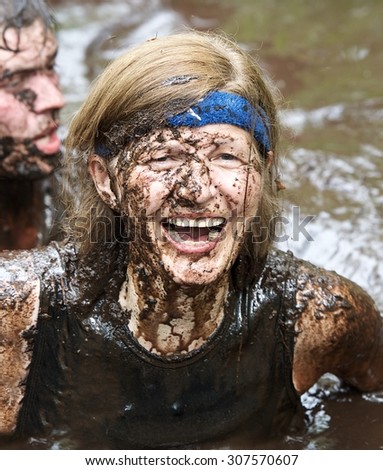 Sirvintos, Lithuania - August 9: A woman covered by mud in her face during the Beaver run or Lithuanian version of Tough Mudder in Sirvintos, Lithuania on August 9, 2015.