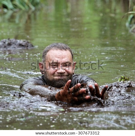 Sirvintos, Lithuania - Aug 9: Man swimming in the dirty wild swamp in Lithuania on Aug 9, 2015. Extreme trip through the swamp