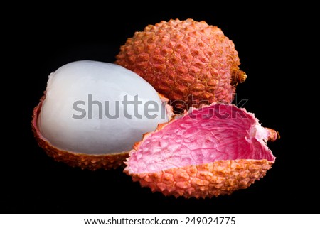 Single litchi with skin removed and flesh. On black.