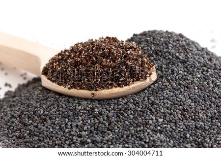 Wooden spoon with ground poppy seeds and whole seeds.