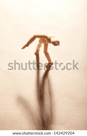 A wooden figure with its shadow.