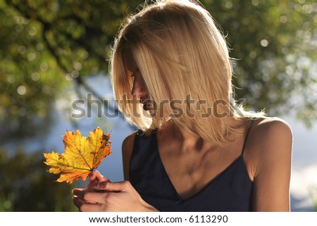 Nice autumn portrait with blond girl and maple leave