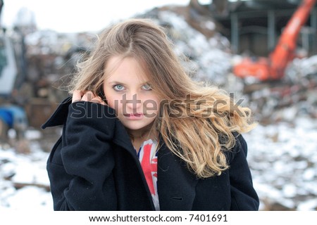Girl in warm clothes during cold december day, garbage in background
