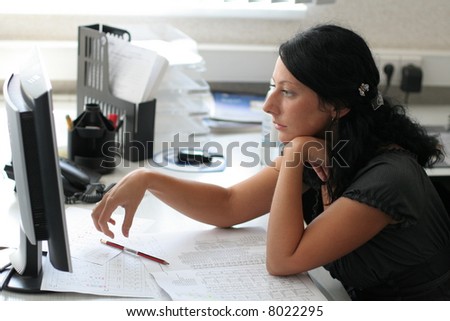 Girl works in office with computer and paper works