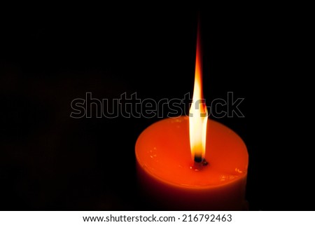 A burning candle in dark.