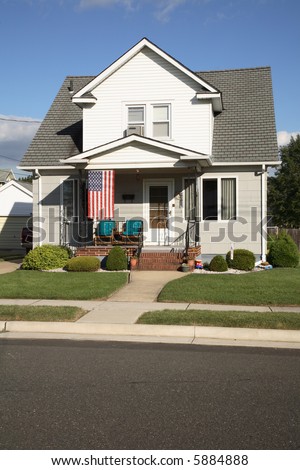 A modest house with an American flag, in a small town.