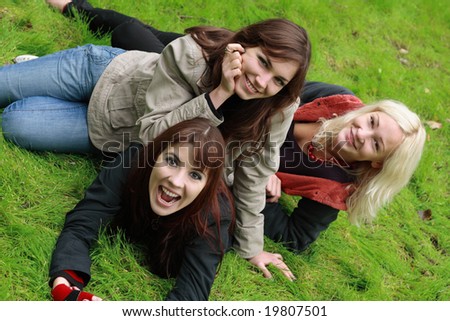 Company of girls having fun on green grass