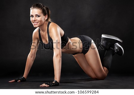 Young fit woman in sports outfit, doing push-ups
