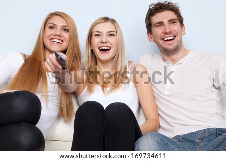 Group of young people watching tv at home