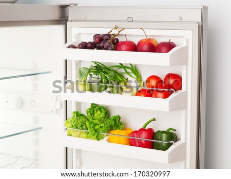 Open refrigerator full of fresh fruit and vegetables