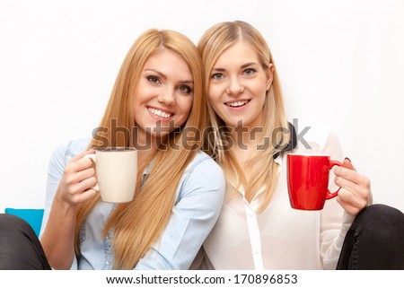 Two female friends drinking coffee and chatting