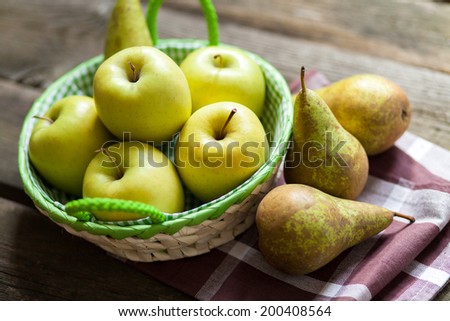 Fresh green apples and pears on a wooden table