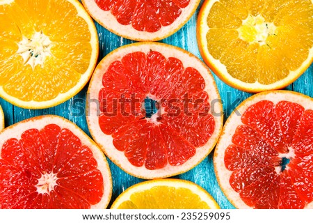 Red grapefruit slices on blue wooden background