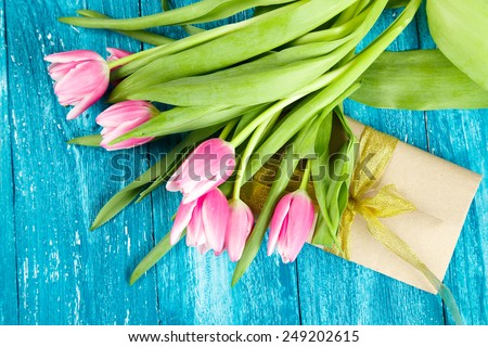 Beautiful pink tulips on blue wood background.