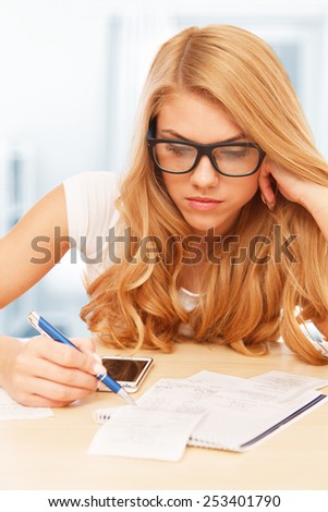 Young attractive woman doing her accounts