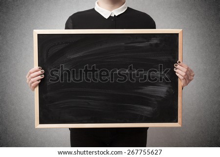 Woman holding a blank blackboard with space for text