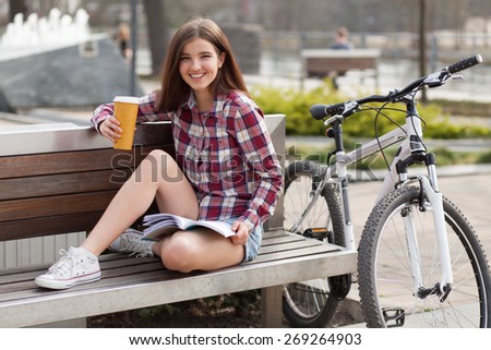 Young woman drinking coffee on a bicycle trip.