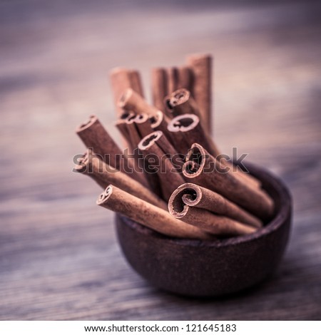 Close-up of Cinnamon sticks. Wooden table on a background. Focus on front stick.