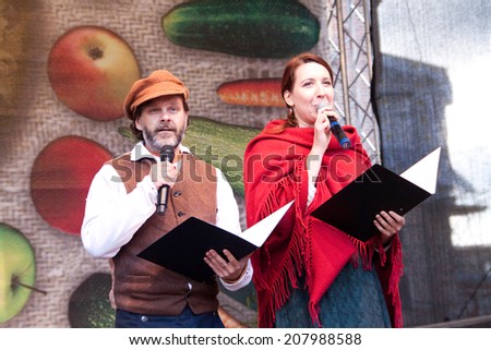 RIGA, LATVIA - SEPTEMBER 28, 2013: People in national costumes perform traditional songs on the scene during the Latvian harvest holiday Mikeldienas.