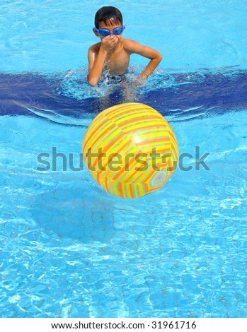 Kid plays with light yellow ball inside swimming pool