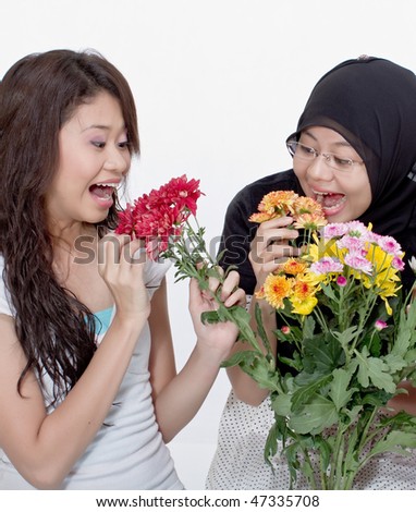 Cheerful teenagers hold flowers on isolated background
