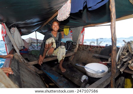 SEMPORNA, MALAYSIA - JULY 3 : Unidentified Sea Bajau\'s woman sit on a boat house on July 3, 2009 in Sabah, Malaysia. The Sea Gypsies are sea nomads that move from one place to another.