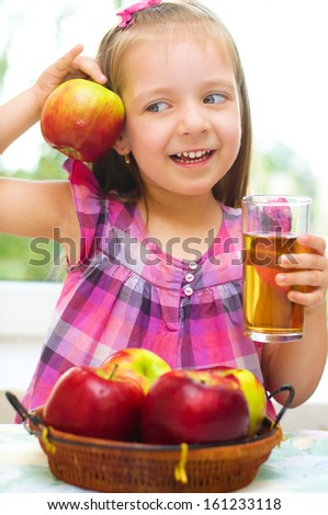 cute little girl holding apples at home