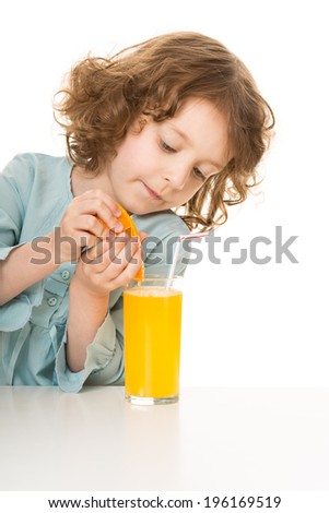 cute little girl makes juice from an orange, isolated over white