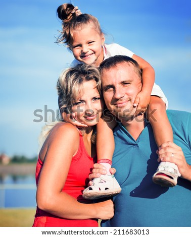 Family concept. Portrait of a happy family of three having fun together outdoors